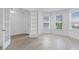 Bright and airy living room with three large windows, white trim and light wood look floors at 4198 Barbuda Ln, Kissimmee, FL 34758