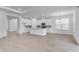 Large open-concept space featuring a modern kitchen with island, dining area, and living room, all with light-colored flooring at 4198 Barbuda Ln, Kissimmee, FL 34758