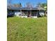 Backyard view with screened porch and green grass at 4202 Mizell St, Orlando, FL 32812