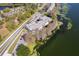 Aerial view of a condominium building bordering a lush, tree-lined lake at 4575 S Texas Ave # 205, Orlando, FL 32839