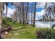 Lush backyard with a walking path leads to serene lake views and towering trees at 4575 S Texas Ave # 205, Orlando, FL 32839