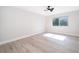 Bright bedroom features light wood floors, neutral walls, a ceiling fan, and a window overlooking a green outdoor view at 4575 S Texas Ave # 205, Orlando, FL 32839