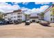 Multi-story condominium building featuring a parking lot and tropical landscaping at 4575 S Texas Ave # 205, Orlando, FL 32839