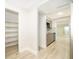 Hallway view featuring a pantry with shelves, a glimpse of the modern kitchen, and light wood flooring at 4575 S Texas Ave # 205, Orlando, FL 32839