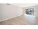 Bright living room with modern wood floors and sliding glass door to a large window overlooking the water at 4575 S Texas Ave # 205, Orlando, FL 32839