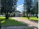 Brick driveway leading to a charming home surrounded by lush green lawns and mature landscaping for a picturesque curb appeal at 4847 Lake Milly Dr, Orlando, FL 32839