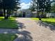 Brick driveway leads to a lovely home, enhanced by lush green lawns and mature landscaping, creating a welcoming approach at 4847 Lake Milly Dr, Orlando, FL 32839