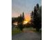Scenic street view at sunset, with mature trees framing the sky and a brick-paved driveway leading to a well-kept home at 4847 Lake Milly Dr, Orlando, FL 32839