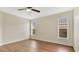 Comfortable bedroom with ceiling fan, wood-look flooring and natural light from multiple windows at 5071 Heatherstone Dr, Kissimmee, FL 34758