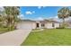 Charming one-story home featuring a well-manicured lawn and a spacious two-car garage with palm trees at 5071 Heatherstone Dr, Kissimmee, FL 34758