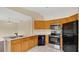 Kitchen with modern appliances, white countertops, and a combination of tile flooring and light wood cabinets at 5071 Heatherstone Dr, Kissimmee, FL 34758