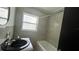 Bathroom featuring tiled walls, modern black vanity and a bathtub with shower at 5200 Brosche Rd, Orlando, FL 32807