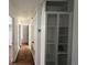 Hallway with tile floors, white walls and storage leading towards other rooms of the house at 5200 Brosche Rd, Orlando, FL 32807