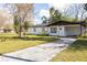 Charming one-story home featuring a crisp white exterior and a spacious driveway on a sunny day at 5604 7Th Se St, Lakeland, FL 33812