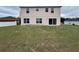 The backyard with a sliding glass door leading to the patio at 607 Kissimmee Ln, Kissimmee, FL 34759