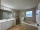 Bathroom featuring a shower, tub, vanity with sink, and tiled floors for a luxurious experience at 607 Kissimmee Ln, Kissimmee, FL 34759