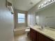 Bathroom features a shower-tub combo, vanity with sink, mirror, and tiled flooring at 607 Kissimmee Ln, Kissimmee, FL 34759