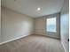 A cozy bedroom features a window, neutral-colored walls, carpet, and a ceiling light at 607 Kissimmee Ln, Kissimmee, FL 34759