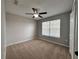 Bedroom with neutral walls, carpet flooring, a window, and a ceiling fan at 607 Kissimmee Ln, Kissimmee, FL 34759