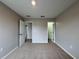 Bedroom with neutral walls, carpet flooring, and doors leading to other rooms and a closet at 607 Kissimmee Ln, Kissimmee, FL 34759