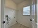 Bright laundry room with window, tile floor, and open shelving at 607 Kissimmee Ln, Kissimmee, FL 34759