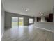 Spacious living room with tile floors, natural light, and an open design leading into the kitchen area at 607 Kissimmee Ln, Kissimmee, FL 34759