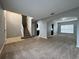 View of the living room with neutral colored walls and carpet and an arched doorway into an adjoining room at 607 Kissimmee Ln, Kissimmee, FL 34759