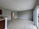 A large living room features tile flooring, gray walls, and an open design leading to adjacent rooms at 607 Kissimmee Ln, Kissimmee, FL 34759