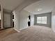 Spacious living room with neutral walls and carpet with an archway into the kitchen with ample natural light at 607 Kissimmee Ln, Kissimmee, FL 34759