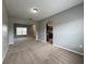 Spacious living room featuring neutral walls and carpet and an archway into the kitchen at 607 Kissimmee Ln, Kissimmee, FL 34759