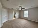 Spacious main bedroom featuring neutral walls, plush carpeting, and a ceiling fan, complemented by an en-suite bathroom at 607 Kissimmee Ln, Kissimmee, FL 34759