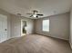 Spacious main bedroom featuring neutral walls, plush carpeting, and a ceiling fan, complemented by an en-suite bathroom at 607 Kissimmee Ln, Kissimmee, FL 34759
