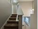 Carpeted staircase with white railing leads to the upper level, bathed in natural light, enhancing the home's interior at 607 Kissimmee Ln, Kissimmee, FL 34759