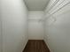 Interior view of a walk-in closet, featuring neutral walls, carpeting, and metal storage shelving at 607 Kissimmee Ln, Kissimmee, FL 34759