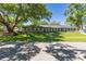 Attractive single-story home with gray siding, white shutters, and a well-maintained lawn and mature trees at 7614 Lake Dr, Belle Isle, FL 32809