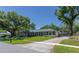 Charming single story home with a lush green lawn, mature trees, and a long driveway at 7614 Lake Dr, Belle Isle, FL 32809