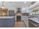 Contemporary kitchen featuring stainless steel appliances, custom white cabinetry, and a gray center island at 7614 Lake Dr, Belle Isle, FL 32809