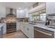Well-lit kitchen featuring modern stainless steel appliances, white cabinetry, and a large picture window at 7614 Lake Dr, Belle Isle, FL 32809