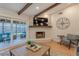 Cozy living room with a brick fireplace, sliding glass doors to the backyard patio, and comfortable seating at 7614 Lake Dr, Belle Isle, FL 32809