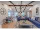 Bright and airy living room showcasing exposed beams, hardwood floors, and seamless transition into dining area at 7614 Lake Dr, Belle Isle, FL 32809