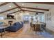 Open concept living space with a fireplace, wood beams, dining area, and a view into the modern kitchen at 7614 Lake Dr, Belle Isle, FL 32809