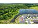Stunning aerial view of the home with a large lake and lush green forest in the background at 780 Livestock Loop, St Cloud, FL 34771