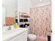 Bathroom featuring a single vanity, decorative floral shower curtain, and organized shelving for towels and toiletries at 780 Livestock Loop, St Cloud, FL 34771