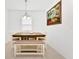 Cozy dining room with a wooden table, bench seating, modern light fixture and a decorative wall painting at 780 Livestock Loop, St Cloud, FL 34771