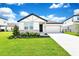 Well-maintained single-story home with a two-car garage, lush lawn, and attractive landscaping at 780 Livestock Loop, St Cloud, FL 34771