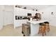 Spacious kitchen featuring white cabinets, stainless steel appliances, a central island with seating and tile floors at 780 Livestock Loop, St Cloud, FL 34771