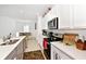 Bright kitchen featuring stainless steel appliances, quartz countertops, and an open layout to the dining area at 780 Livestock Loop, St Cloud, FL 34771