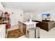 Open-concept kitchen featuring a large island, white cabinetry, stainless steel appliances and view to the living room at 780 Livestock Loop, St Cloud, FL 34771
