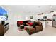 Open-concept living room with a leather sofa, large TV, and seamless flow into the kitchen and dining at 780 Livestock Loop, St Cloud, FL 34771
