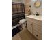 Bathroom with white vanity, decorative mirror and tiled shower with patterned curtain at 7813 Arabian Pl, Orlando, FL 32818